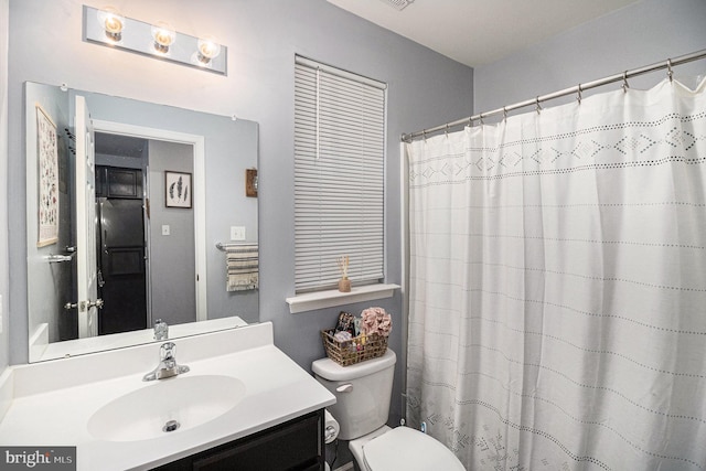 bathroom with a shower with shower curtain, vanity, and toilet