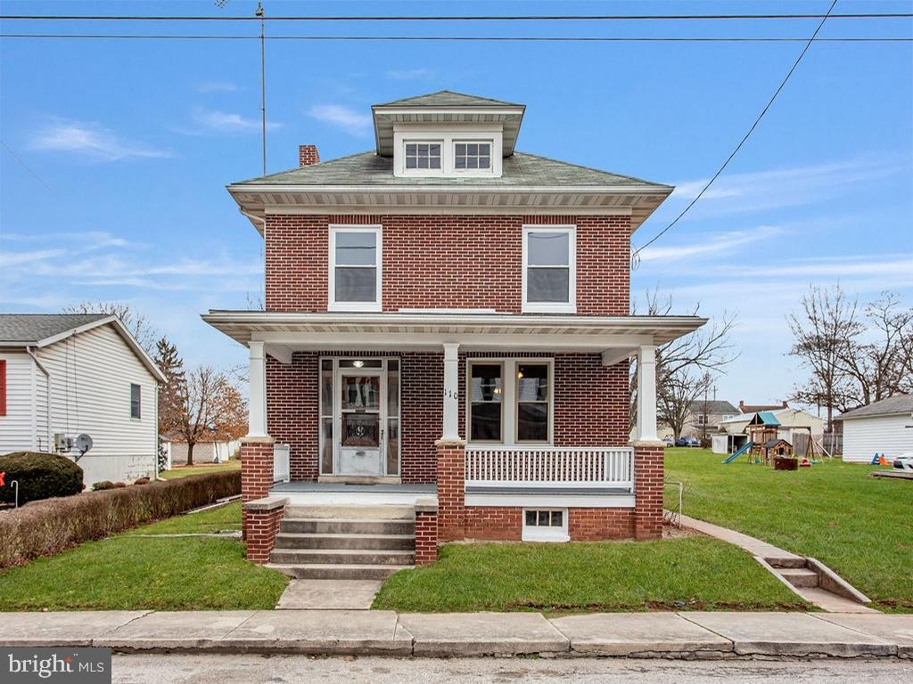 front facade featuring a porch, a playground, and a front lawn