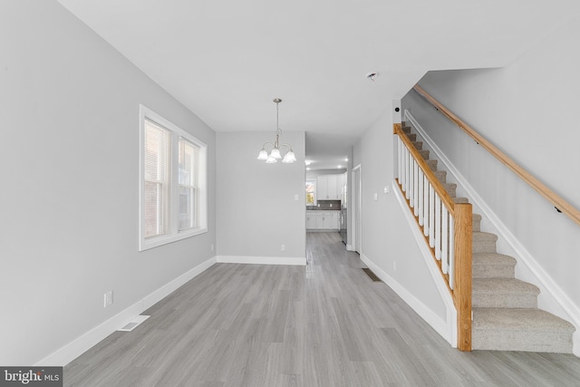 interior space featuring light hardwood / wood-style flooring and a chandelier