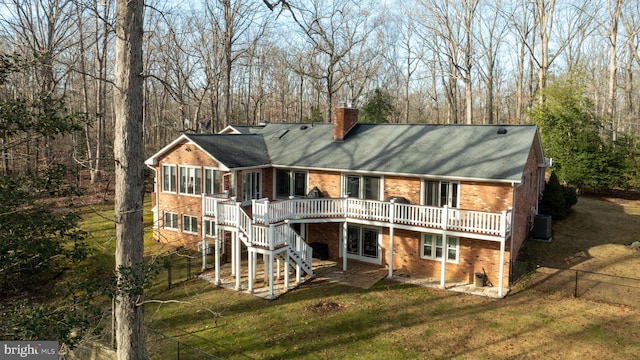 back of property with central AC, a sunroom, a deck, and a lawn