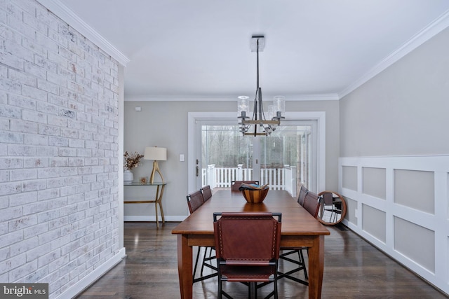 dining area featuring a notable chandelier, dark hardwood / wood-style floors, crown molding, and brick wall