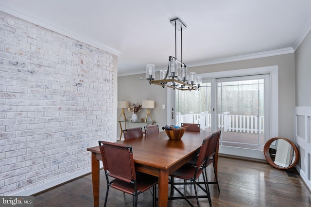 dining space featuring dark wood-type flooring, an inviting chandelier, crown molding, and brick wall