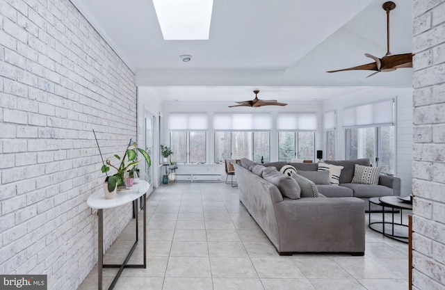 living room featuring light tile patterned floors, a skylight, and brick wall