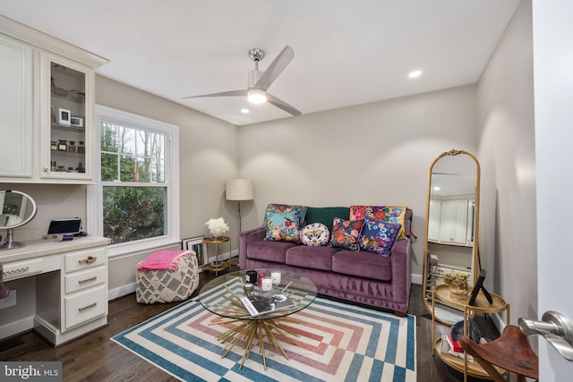 living room with ceiling fan and dark wood-type flooring