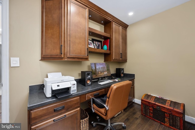 office with built in desk and dark hardwood / wood-style floors