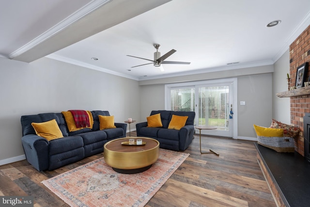 living room featuring ceiling fan, dark hardwood / wood-style flooring, ornamental molding, and a fireplace