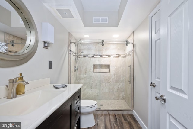 bathroom featuring wood-type flooring, vanity, toilet, and a shower with door