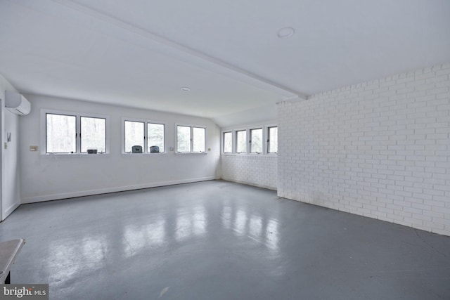 spare room with beam ceiling, a wall mounted AC, and brick wall