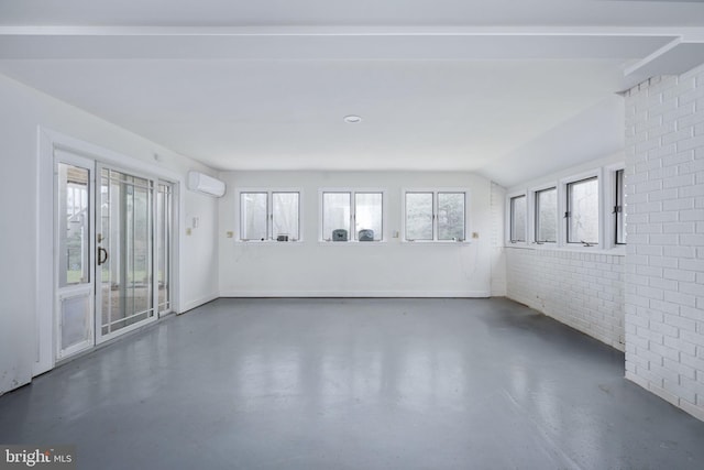 spare room with plenty of natural light, lofted ceiling, brick wall, and a wall mounted AC