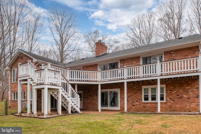 back of property with a yard and a wooden deck