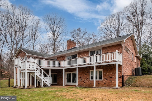 back of house featuring central AC unit, a lawn, and a wooden deck