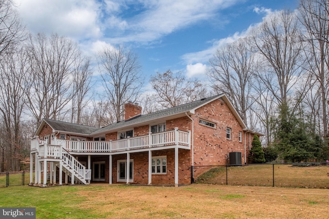 back of property with a lawn, a wooden deck, and cooling unit