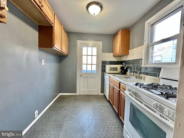 kitchen with sink, white appliances, and decorative backsplash