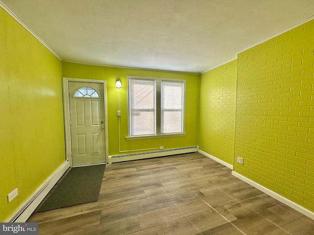 foyer featuring light hardwood / wood-style flooring, brick wall, and a baseboard heating unit