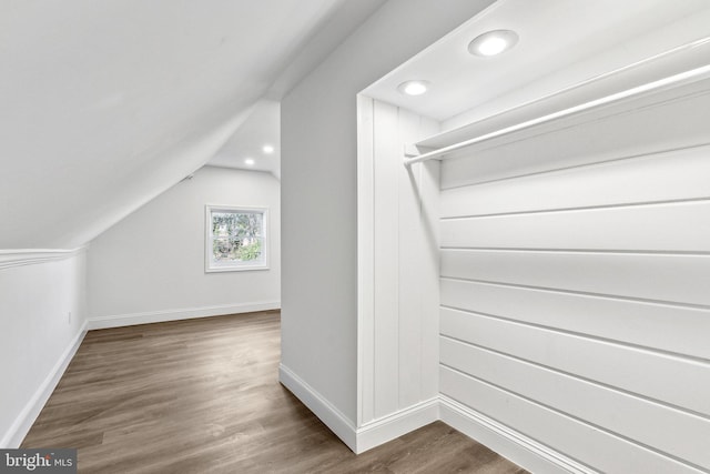 additional living space featuring dark wood-type flooring and vaulted ceiling