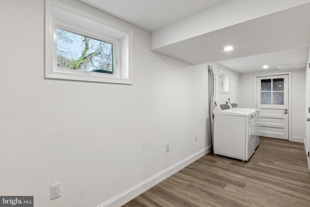 laundry area with separate washer and dryer and light hardwood / wood-style flooring