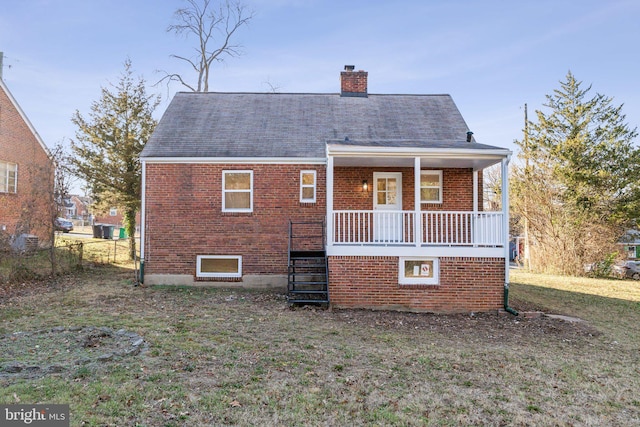 back of house featuring a porch and a lawn