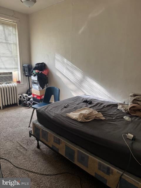 carpeted bedroom featuring radiator and cooling unit