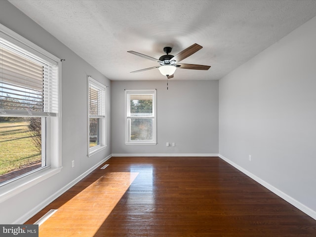 spare room with a textured ceiling, dark hardwood / wood-style flooring, and ceiling fan