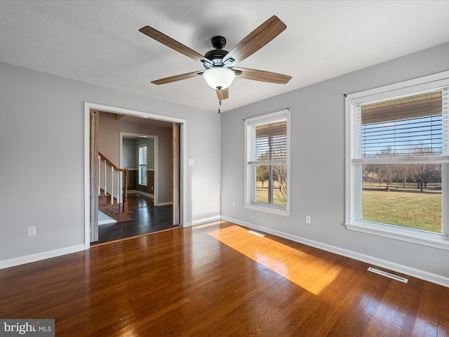 spare room with dark hardwood / wood-style floors and ceiling fan