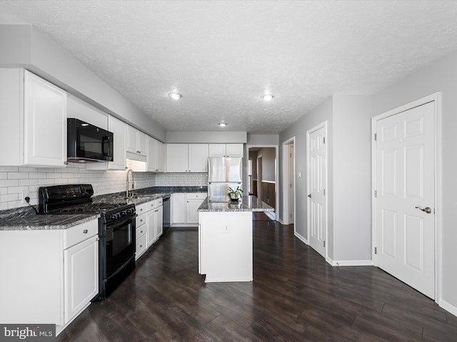 kitchen featuring white cabinets, a textured ceiling, a center island, and black appliances