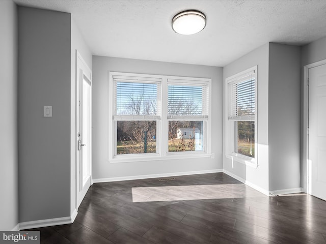 foyer entrance featuring dark hardwood / wood-style flooring, plenty of natural light, and a textured ceiling