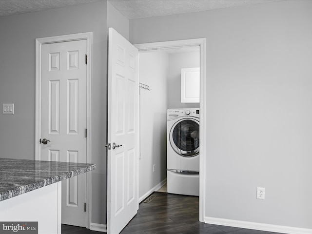 laundry room with washer / clothes dryer, dark wood-type flooring, cabinets, and a textured ceiling