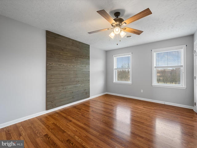 spare room with ceiling fan, hardwood / wood-style floors, and a textured ceiling