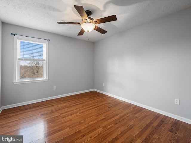 spare room featuring a textured ceiling, ceiling fan, and dark wood-type flooring