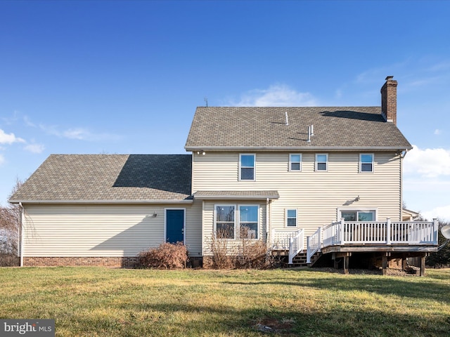 back of property featuring a wooden deck and a lawn