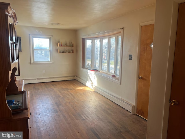 interior space with a baseboard radiator and hardwood / wood-style flooring