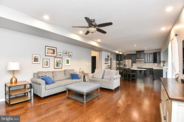 living room with ceiling fan and dark hardwood / wood-style floors