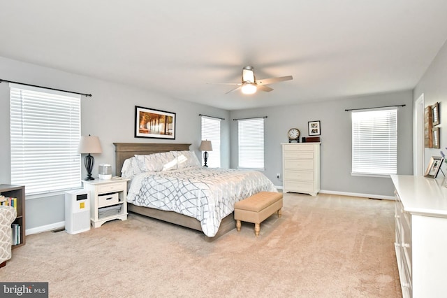 carpeted bedroom with multiple windows and ceiling fan