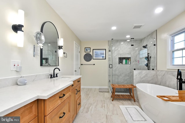 bathroom featuring vanity and independent shower and bath