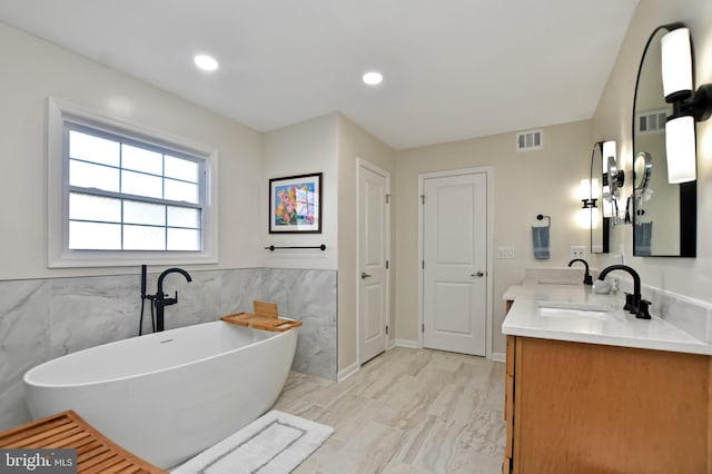 bathroom with a washtub and vanity