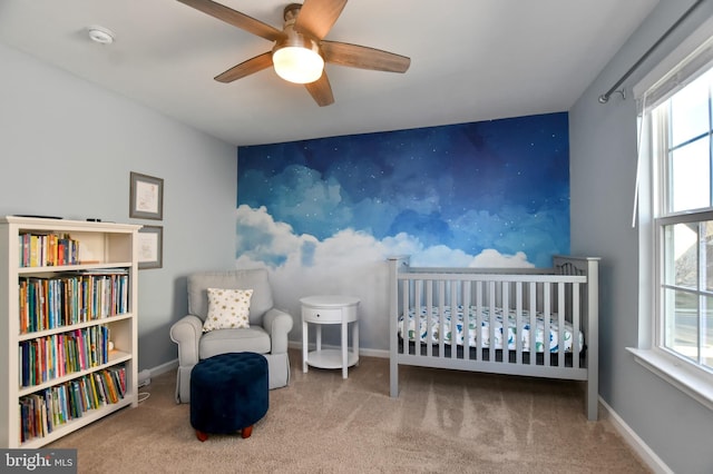 bedroom featuring carpet flooring, ceiling fan, and a crib