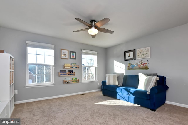 living area featuring light carpet and ceiling fan