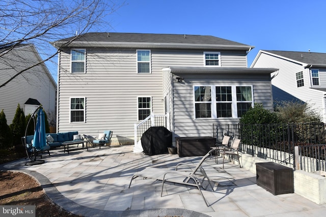 rear view of property featuring outdoor lounge area, a jacuzzi, and a patio area