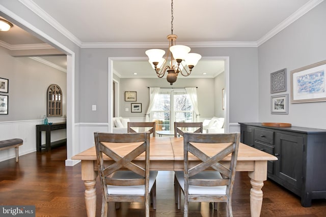 dining area featuring dark hardwood / wood-style floors, crown molding, and an inviting chandelier