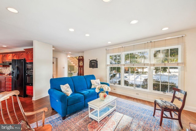 living area featuring recessed lighting, wood finished floors, visible vents, and baseboards