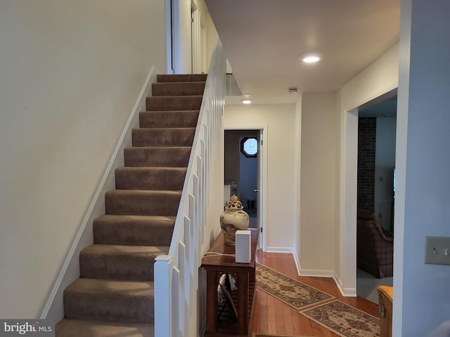 staircase with hardwood / wood-style flooring