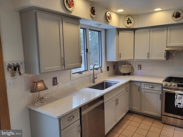 kitchen with backsplash, sink, light tile patterned floors, and appliances with stainless steel finishes