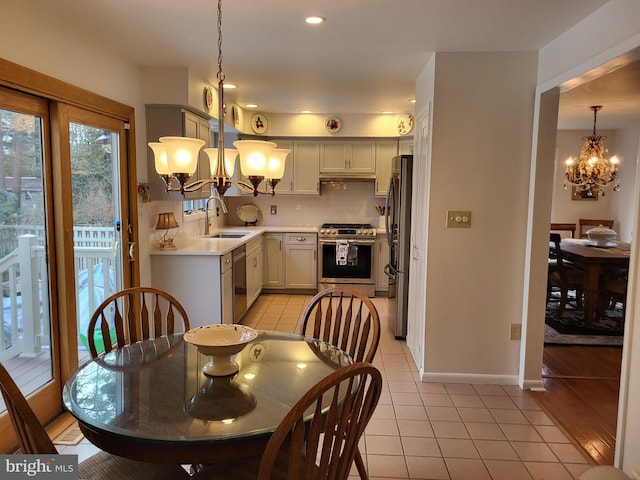 tiled dining room featuring sink and a chandelier