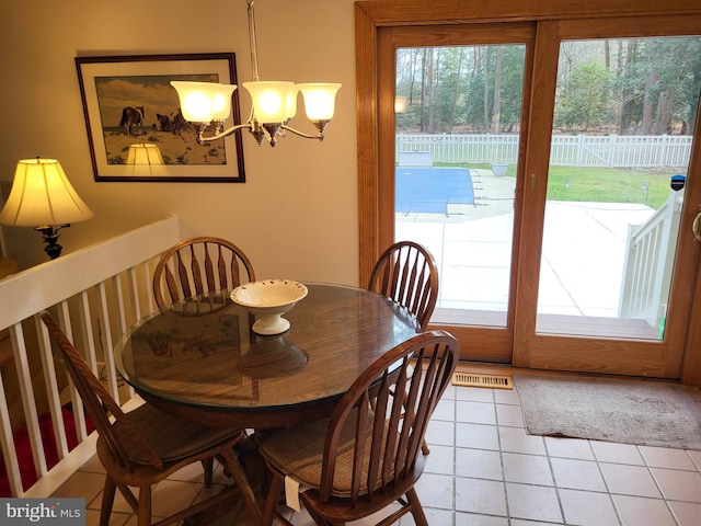 dining space with tile patterned flooring and an inviting chandelier