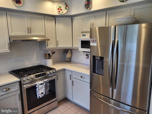 kitchen with backsplash, gray cabinets, light tile patterned flooring, and stainless steel appliances