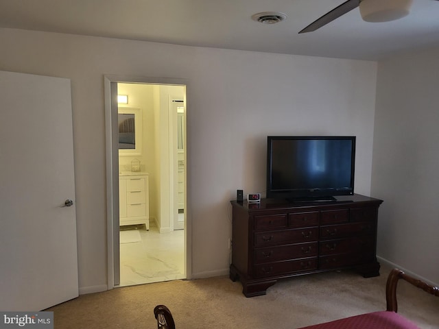 bedroom with ensuite bathroom, ceiling fan, and light colored carpet