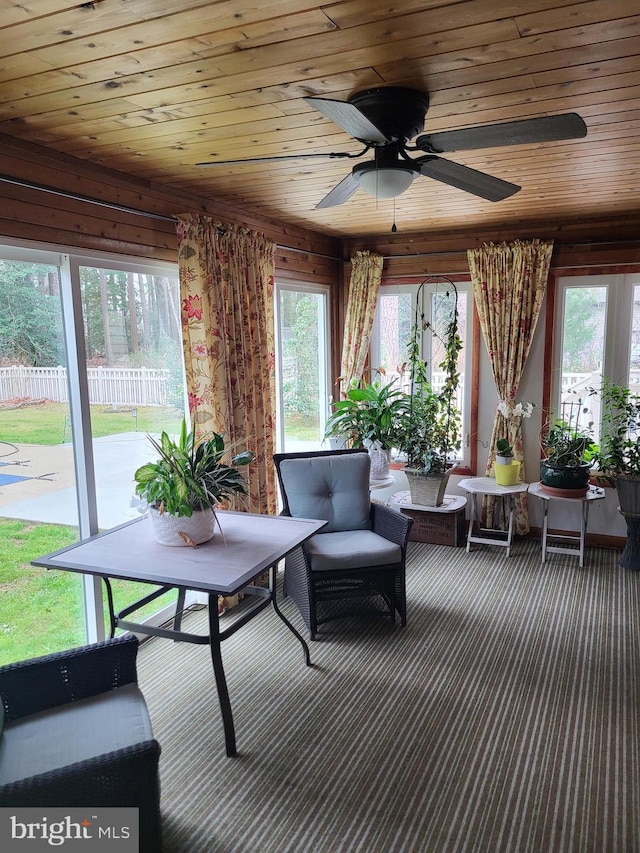 sunroom / solarium featuring a healthy amount of sunlight and wooden ceiling