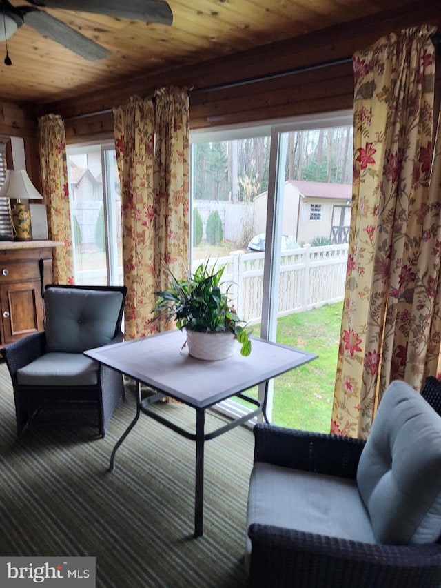 sitting room with ceiling fan, wooden ceiling, and carpet floors