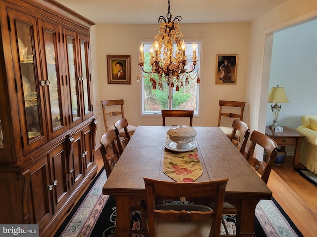 dining space with dark wood-type flooring and a chandelier