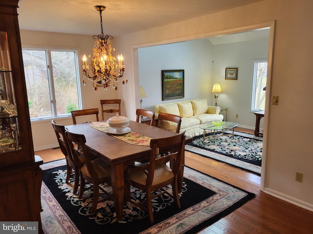 dining space featuring dark hardwood / wood-style flooring and a chandelier